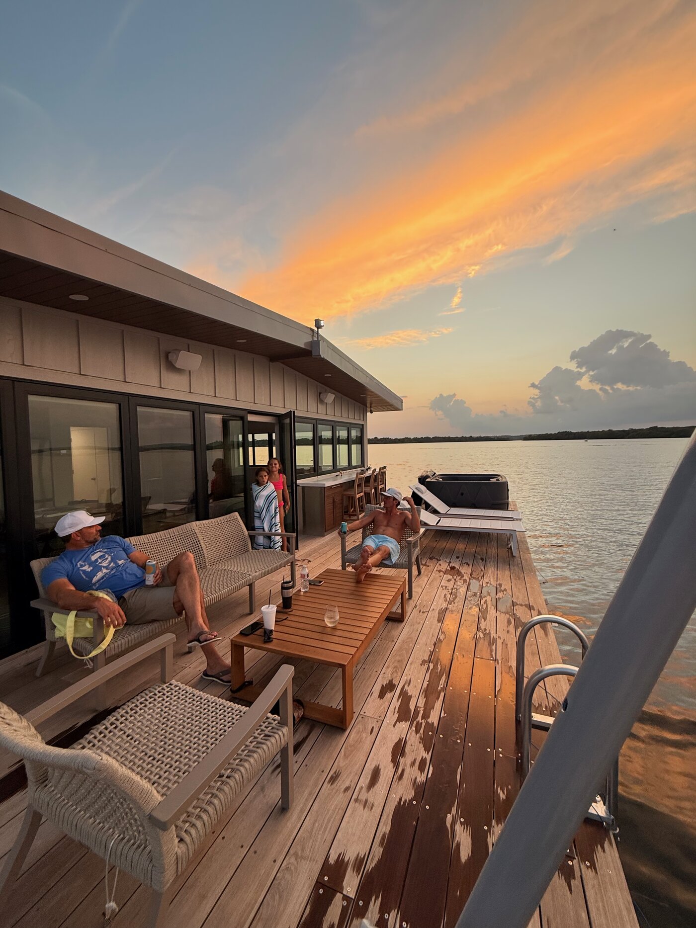 Family relaxing on the Dockboat deck at sunset on Grand Lake